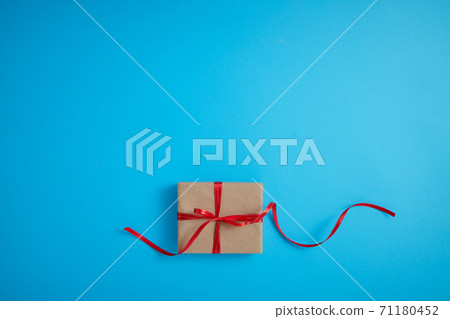 Gift box with a red bow on a blue 71180452