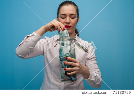 Young charming woman holds a jar with money 71180799