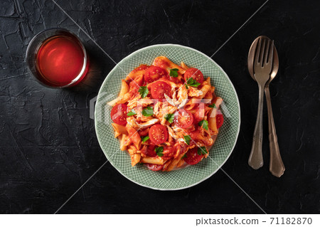 Red pasta. Penne with chicken, tomato sauce and parsley, shot from the top with a glass of wine 71182870