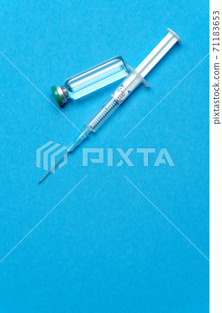 Syringe and ampoules with medicines or vaccine over blue background Syringe and ampoules with medicines or vaccine over blue background 71183653