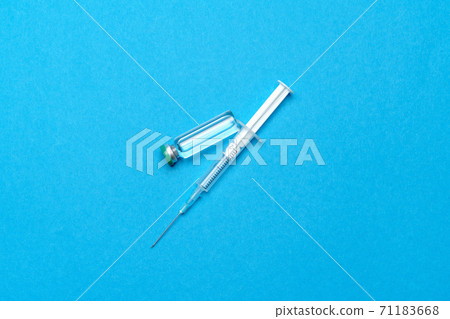 Syringe and ampoules with medicines or vaccine over blue background 71183668
