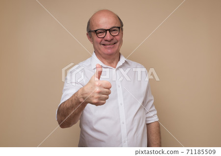 Cheerful senior man giving thumb up approving your choice Cheerful senior man giving thumb up approving your choice 71185509