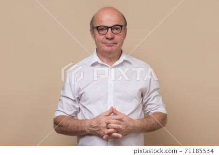 Elegant senior bald man with glasses smiling confident at camera. Elegant senior bald man with glasses smiling confident at camera. 71185534