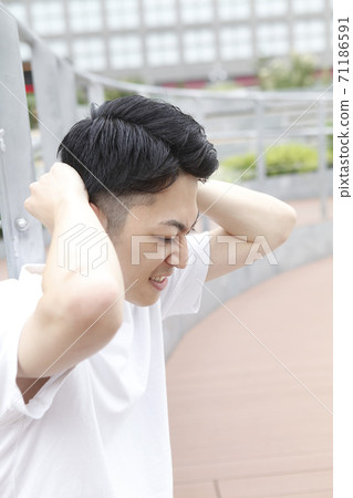 Young man holding his head Young man holding his head 71186591