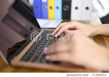 Female hands on laptop keyboard are typing text. 71186931