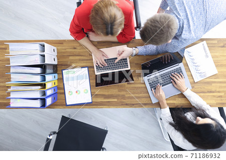 Business people sit at their desk and discuss development strategy Business people sit at their desk and discuss development strategy 71186932