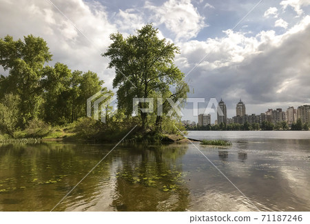 Beautiful view of the lake and trees before a thunderstorm, dark clouds in the sky Beautiful view of the lake and trees before a thunderstorm, dark clouds in the sky 71187246