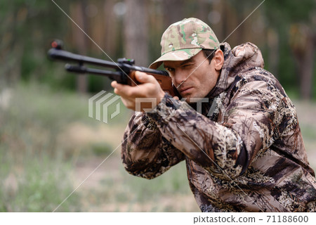 Young Man is Aiming with Shotgun Rabbit Hunt. 71188600