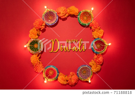 Happy Diwali - Clay Diya lamps lit during Dipavali, Hindu festival of lights celebration. Colorful traditional oil lamp diya on pink background 71188818