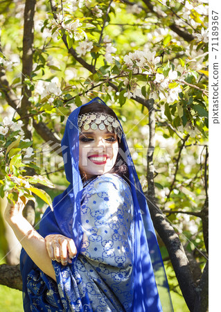 young pretty indian girl in jewelry and veil posing cheerful happy smiling in green park, lifestyle people concept 71189367