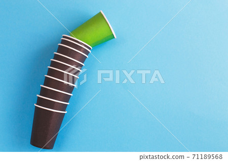 Eco-friendly disposable brown and green paper cups on blue background. Ecology concept. Eco-friendly disposable brown and green paper cups on blue background. Ecology concept. 71189568