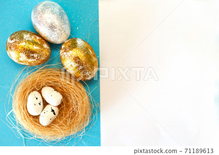 Gold and silver Easter eggs with nest on a blue background. Easter concept. Happy Easter. Copy space 71189613