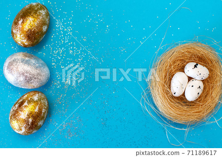 Gold and silver Easter eggs with nest on a blue background. Easter concept. Happy Easter. Copy space 71189617