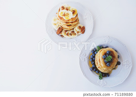 Stack of homemade small thick pancakes served with fresh blueberries. 71189880