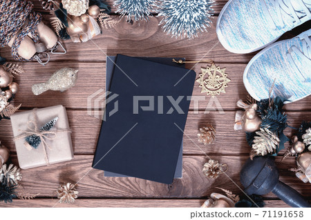 Mockup blank space cover book with empty space for New Year resolutions fitness healthy goals concept, Christmas gift box with Xmas christmas ornaments on wood background with healthy fitness 71191658