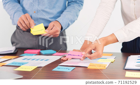 Creative group of business people brainstorming use sticky notes picking to share idea on table decision Choosing Concept for developing plan in business conference room. 71192529