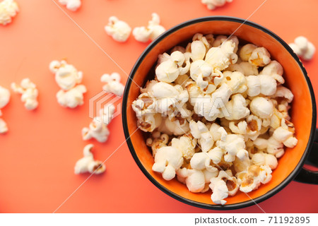 popcorn in a bowl on orange background top view popcorn in a bowl on orange background top view 71192895