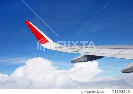 View of sky, cloud and wing from airplane window View of sky, cloud and wing from airplane window 71193296