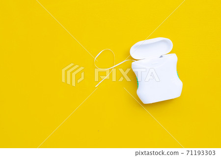 Dental floss on yellow background. Dental floss on yellow background. 71193303