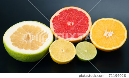 cut pieces of different citrus fruits on dark background 71194028