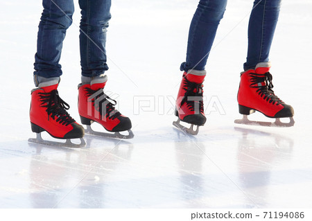 feet in red skates on an ice rink feet in red skates on an ice rink 71194086