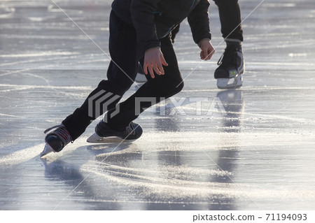 Hobbies and sports. Vacations and winter activities. man actively skates on an ice rink. 71194093