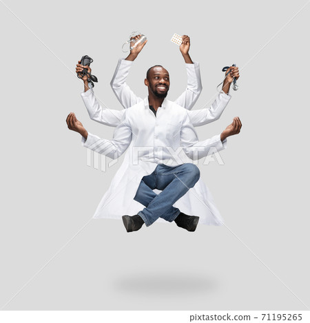 Handsome multi-armed doctor levitating isolated on grey studio background with equipment 71195265