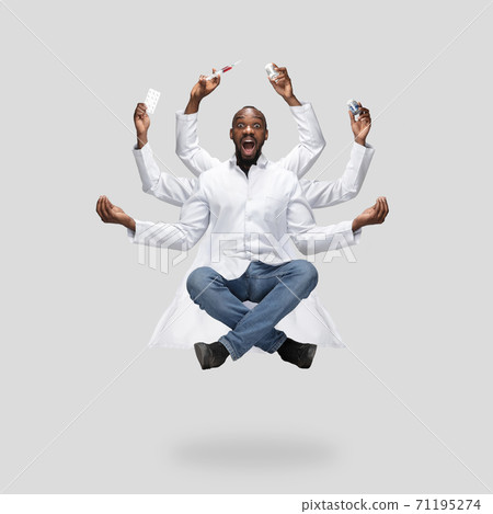 Handsome multi-armed doctor levitating isolated on grey studio background with equipment Handsome multi-armed doctor levitating isolated on grey studio background with equipment 71195274