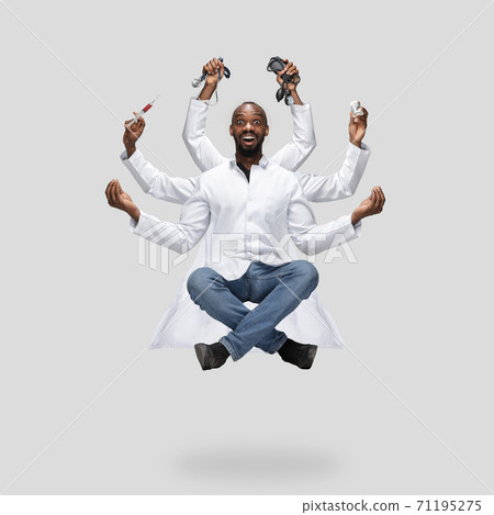 Handsome multi-armed doctor levitating isolated on grey studio background with equipment Handsome multi-armed doctor levitating isolated on grey studio background with equipment 71195275