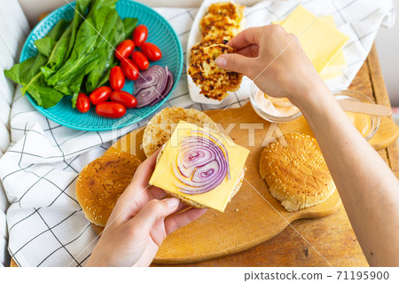Preparation of all the ingredients for making a burger - bun, cutlet, cheese, salad, tomato, sauces. Preparation of all the ingredients for making a burger - bun, cutlet, cheese, salad, tomato, sauces. 71195900