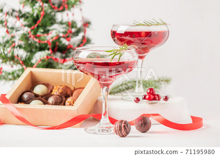 Winter drink cocktail cranberry rosemary glasses white background box chocolates Winter drink cocktail cranberry rosemary glasses white background box chocolates 71195980