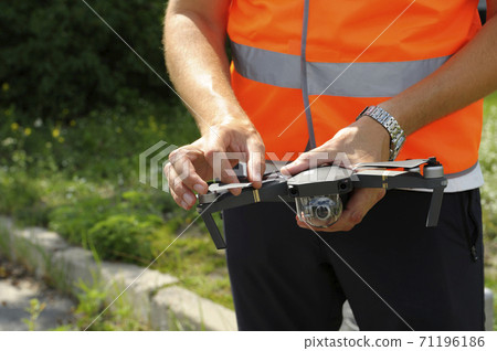 Operator hands adjusting quadcopter before launching it Operator hands adjusting quadcopter before launching it 71196186