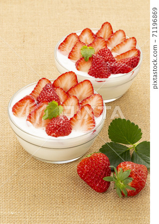 草莓酸奶和很多草莓在亞麻和薄荷的玻璃碗裡 71196869
