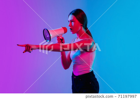 Young caucasian woman's portrait on gradient blue-purple studio background in neon light Young caucasian woman's portrait on gradient blue-purple studio background in neon light 71197997