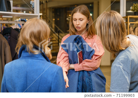 friends choose a coat in the store happy buyers friends choose a coat in the store happy buyers 71199903