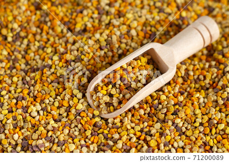 Bee pollen and wooden scoop close-up 71200089