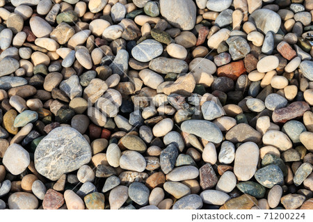 Smooth round pebbles texture background. Pebble sea beach close-up Smooth round pebbles texture background. Pebble sea beach close-up 71200224