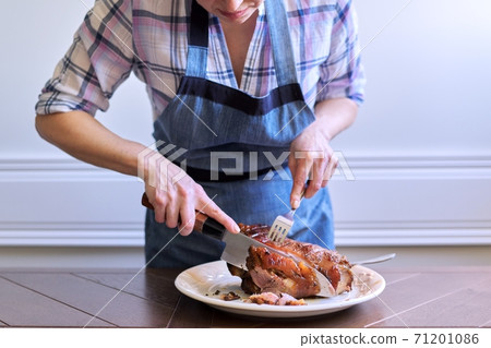 Female hands cutting freshly cooked hot meat on plate Female hands cutting freshly cooked hot meat on plate 71201086