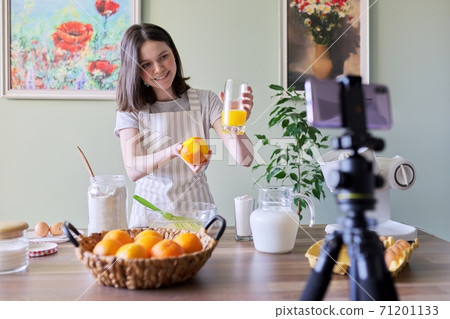 Girl teenager food blogger recording recipe for cooking orange pancakes Girl teenager food blogger recording recipe for cooking orange pancakes 71201133