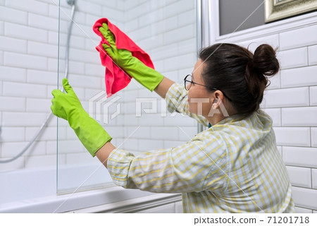 Female cleaning polishing shower glass with a washcloth with microfiber Female cleaning polishing shower glass with a washcloth with microfiber 71201718