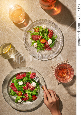 Meat salads on stone sunny table with drinks Meat salads on stone sunny table with drinks 71203165
