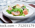 Salad with ham and arugula on white plate 71203179