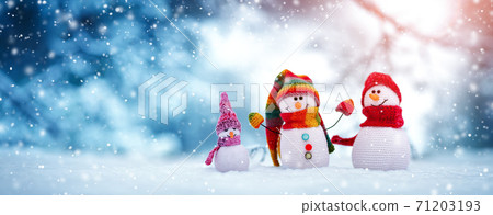 Little knitted snowmen on soft snow on blue background 71203193