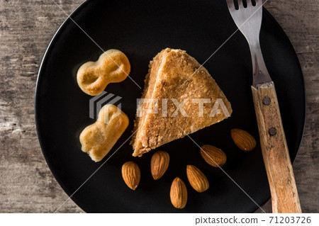 Traditional Christmas marzipan slice on wooden table. 71203726