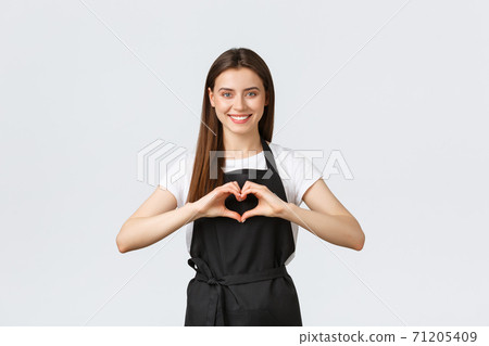 Grocery store employees, small business and coffee shops concept. Lovely friendly-looking barista inviting have taste of new drinks in cafe, showing heart sign to express love for visitors 71205409