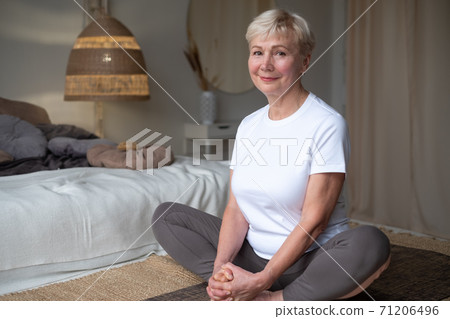 Senior caucasian woman doing yoga or pilates training, sitting in Purna Titli, Baddha Konasana Senior caucasian woman doing yoga or pilates training, sitting in Purna Titli, Baddha Konasana 71206496
