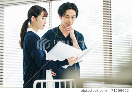 Doctor talking to a nurse 71209632