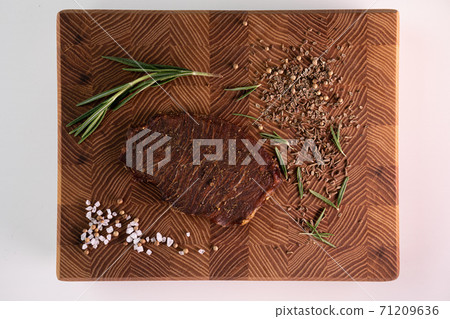 Close-up of a piece of meat on a wooden Board with spices. Restaurant menu, a series of photos of different dishes Close-up of a piece of meat on a wooden Board with spices. Restaurant menu, a series of photos of different dishes 71209636