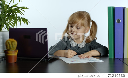 Child schoolgirl learn lessons at home. Distance education during coronavirus quarantine. E-learning Child schoolgirl learn lessons at home. Distance education during coronavirus quarantine. E-learning 71210380