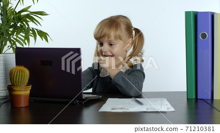 Online learning, distance education, lesson at home. Girl doing school program online on computer Online learning, distance education, lesson at home. Girl doing school program online on computer 71210381